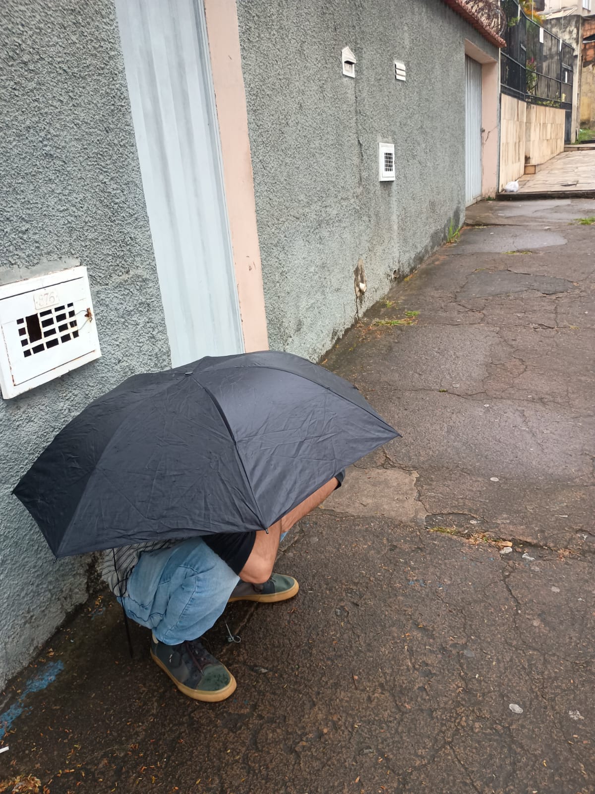 Me, hiding from the rain while waiting for the bus.